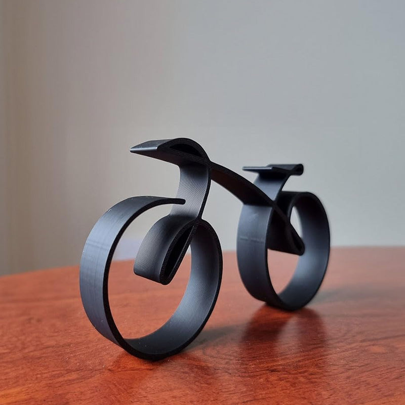 Minimalistisk cykelskulptur i metal med mat trådlook