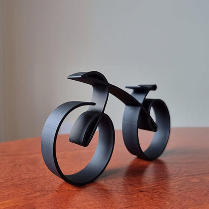 Minimalistisk cykelskulptur i metal med mat trådlook