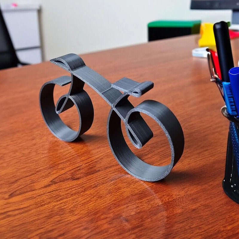 Minimalistisk cykelskulptur i metal med mat trådlook