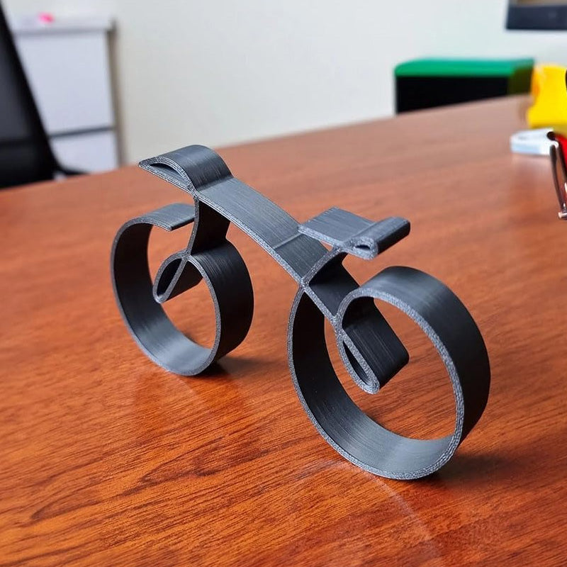 Minimalistisk cykelskulptur i metal med mat trådlook
