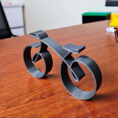 Minimalistisk cykelskulptur i metal med mat trådlook